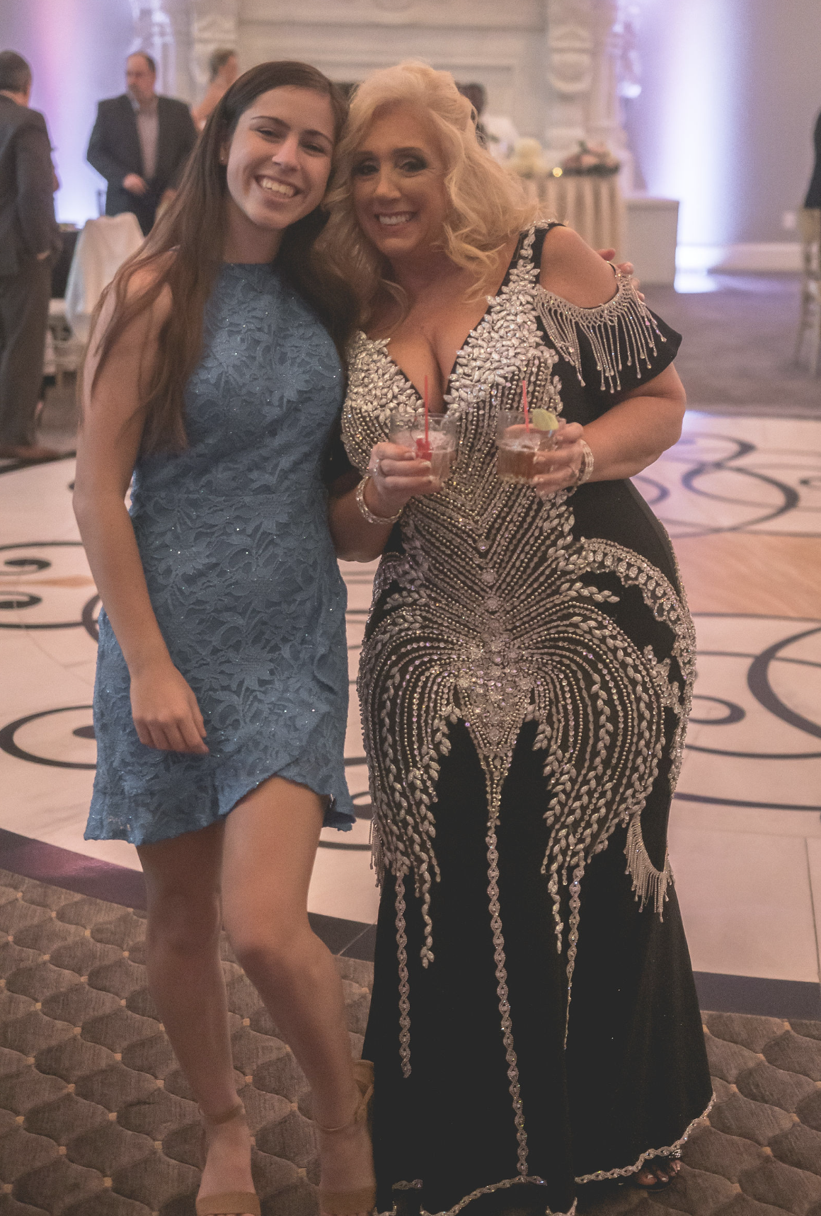 Two guests smiling together at a formal celebration