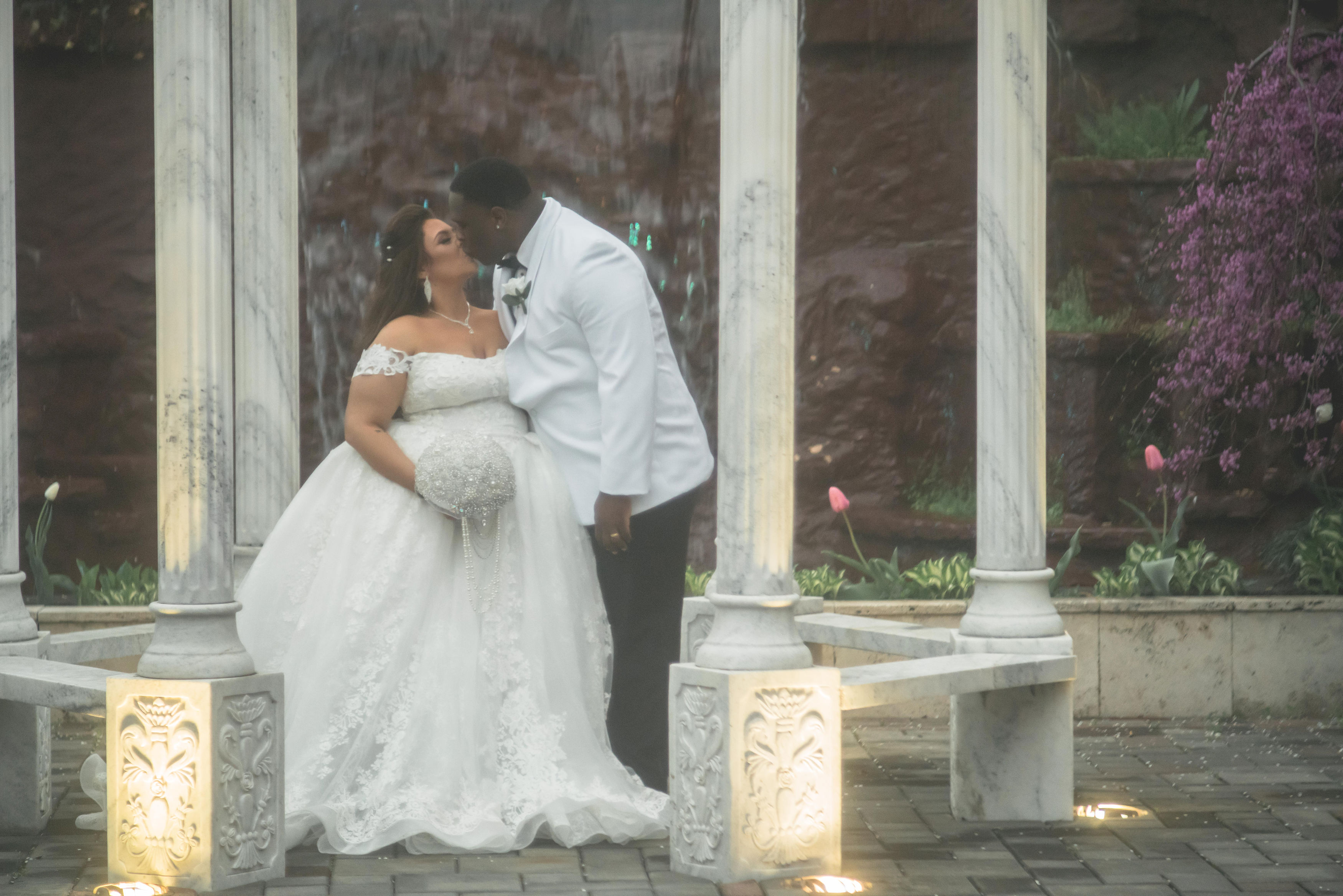 A couple sharing a kiss in a garden on their wedding day