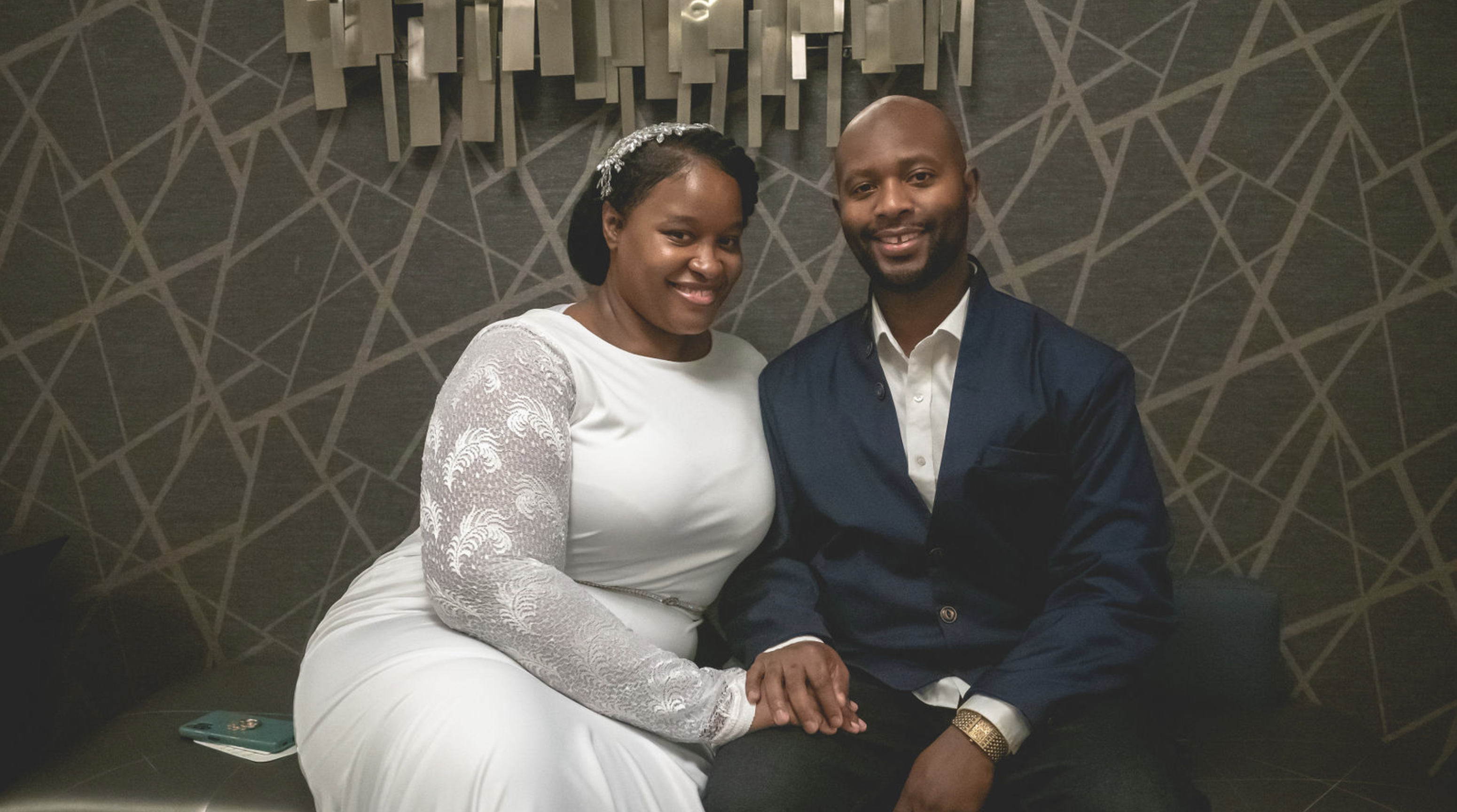 A couple seated together in white and navy formalwear