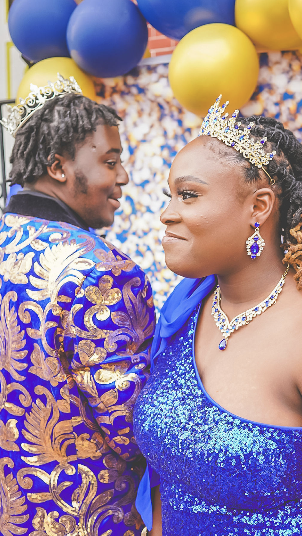 Two people in blue and gold formalwear celebrating a milestone